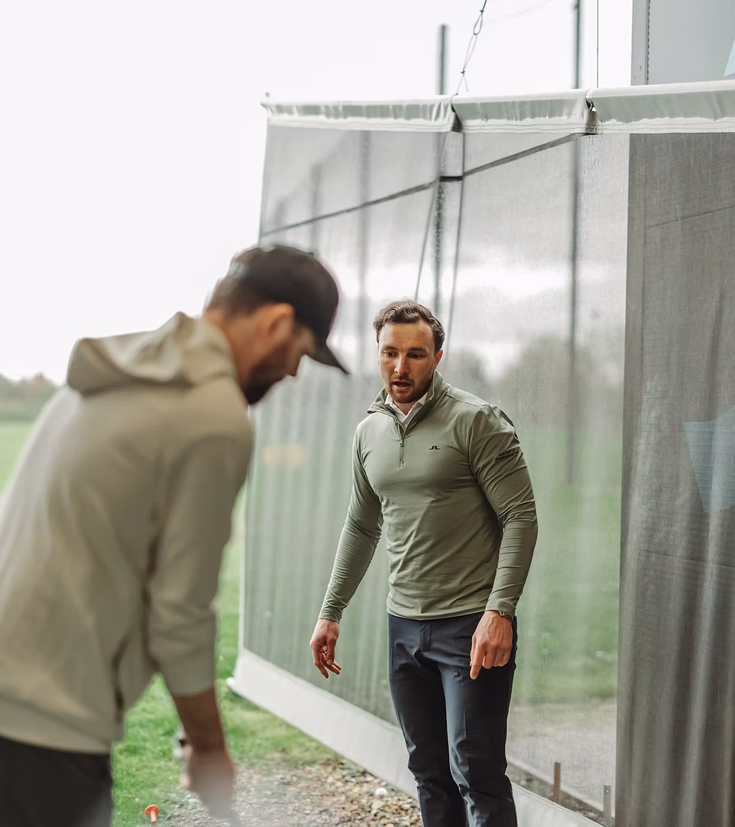 Joe Coyle coaching a golfer on the driving range